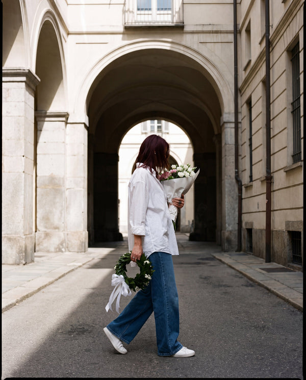 Corona di laurea con alloro e gypsophila portata in un cortile di Torino