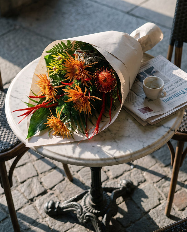 Aranciera, bouquet di crisantemi arancio di Emozioni su un tavolino di caffè a Torino la domenica mattina