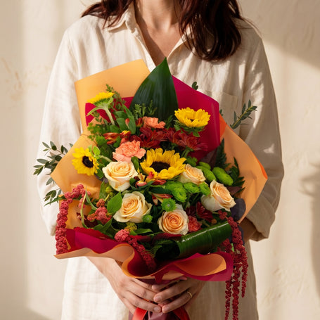 Rigoglio, bouquet con girasoli, rose pesca e garofani — consegna a Torino