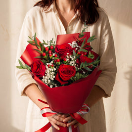 Roseto - bouquet di rose rosse, hypericum e gypsophila, tenuto in mano